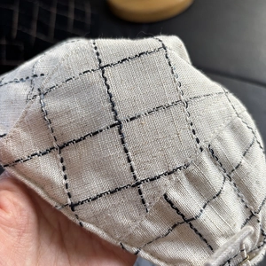 Detailed close-up of breathable linen blend fabric with plaid pattern and textured stitching