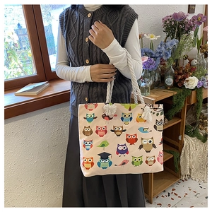 Detail of canvas tote bag featuring colorful owl pattern and rustic hemp rope handles