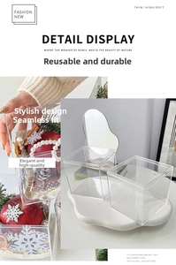 Detail of transparent acrylic gift box with apple and pearl necklace inside