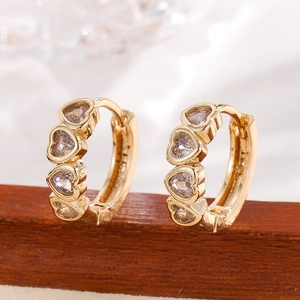 Elegant gold hoop earrings with five heart-shaped cubic zirconia stones on wooden stand