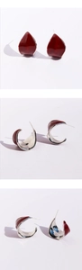 Detail view of burgundy red enamel C-shape hoop earrings with silver metallic interior