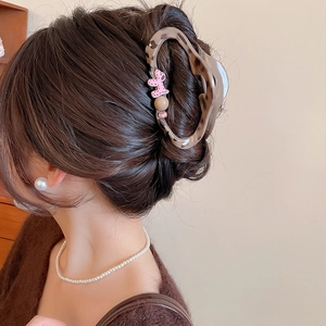 Close-up of tortoise shell hair claw clip with cute pink poodle and crystal detail