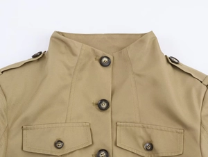 Detailaufnahme einer khakifarbenen Militärjacke mit Stehkragen und Brustpattentaschen