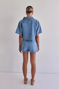 Rear view of two-piece blue denim set featuring a short-sleeve shirt and matching shorts