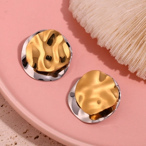 Detail of irregular dual-tone stainless steel studs with wavy texture on pink tray