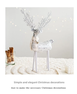Macro detail of a silver sequined Christmas reindeer with a knit scarf and golden bell