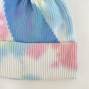 Close-up of thick ribbed knit texture on a pastel tie-dye beanie with gradient colors