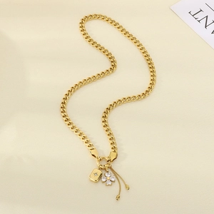 Detail of gold Cuban chain with zircon flower pendant, square tag and bead tassel