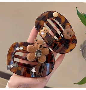 Detail of tortoise shell hair claw clips with flocked bear charms and rhinestone accents