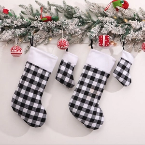 Set of black and white buffalo plaid Christmas stockings hanging on a festive mantel
