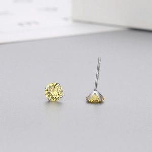 Macro shot of 4-prong S925 sterling silver stud earrings with yellow round-cut zircon stones