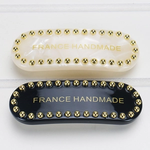 Detail of acetate hair clips with gold studs and France Handmade lettering