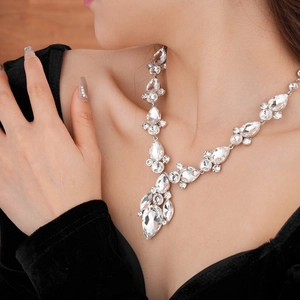 Dettaglio della collana di cristallo su una modella con un abito di velluto nero