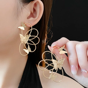 Detailed close-up of elegant golden butterfly earrings featuring hollow line wings
