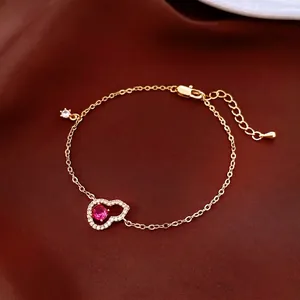 Bracelet plaqué or avec pendentif coeur et pierre rouge sur fond en soie élégante
