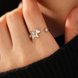 Detailed view of an open unicorn ring with white shell inlay and zircons on a model