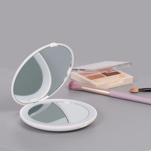 Foldable LED makeup mirror in white, compact round dual-sided design with 2X magnification