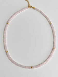 Detailed macro shot of pale pink natural stone beads necklace with gold metal lobster clasp