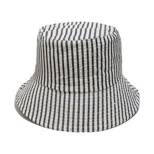 Detail of striped sun hat featuring sparkling rhinestones on textured fabric