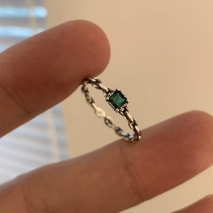 Détail d'un zircon émeraude carré avec anneau de style corde tressée en argent