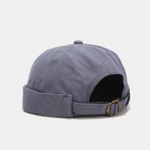 Detail of grey-blue docker cap showing canvas texture and adjustable brass metal buckle