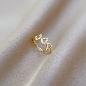 Macro shot of gold adjustable ring with triangular hollow design and micro-inlaid zircons