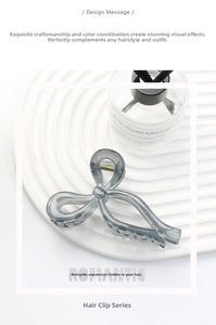 Detailed close-up of dark grey translucent bow-shaped hair claw clip with metal spring