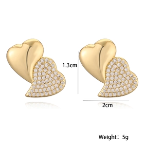 Detail shot of gold heart stud earrings with dimensions 1.3cm by 2cm and weight 5g