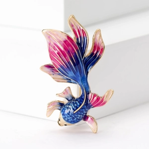 Macro shot of minimalist goldfish brooch with blue and pink enamel finish in gold