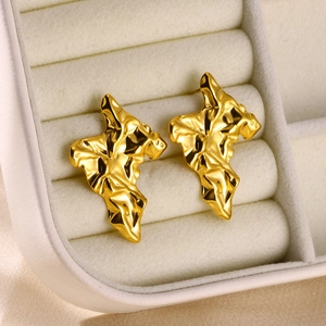 Detail of gold flower stud earrings with irregular wrinkled texture and metallic luster