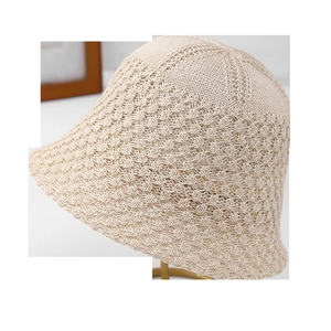 Détail du chapeau cloche au crochet beige avec motif ajouré sur support doré