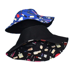 Detail of reversible bucket hat featuring colorful cosmetic prints on navy and black fabric