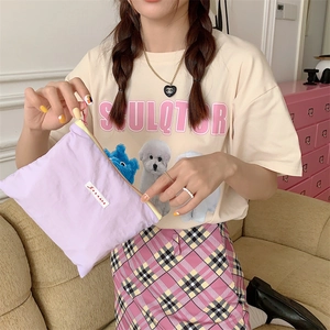 Handheld lavender nylon organizer bag with brand label shown in a lifestyle setting