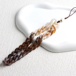 Detail of bohemian acrylic phone strap with dark brown tortoiseshell resin texture