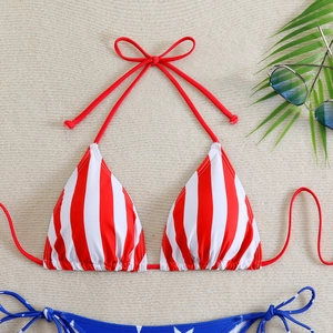 Close-up of American flag bikini top with red stripes and halter tie on a summer beach mat