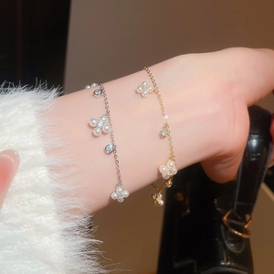Detailed view of elegant silver and gold floral pearl bracelets with zircon accents