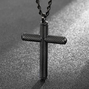Vue macro d'un pendentif croix noire avec texture moletée et chaîne torsadée assortie