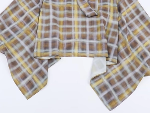 Gros plan sur la texture du tissu en soie à carreaux jaune et gris sur l'ourlet de la jupe
