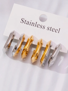 Detail of three pairs of chunky U-shaped stainless steel earrings in gold and silver finish