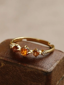 Macro view of adjustable gold ring featuring amber garnets and faceted stones on leather