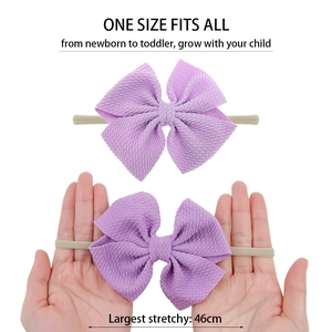 Elastic waffle fabric baby headband with purple bow showing 46cm stretch capacity