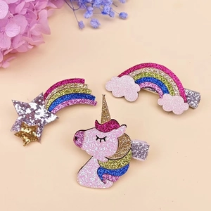 Dettaglio di fermagli per capelli glitterati con unicorno, arcobaleno e stella per bimbe