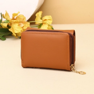 Detailed macro of brown matte PU leather wallet with a gold zipper and round pendant charm