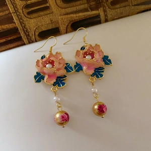 Nahaufnahme der Vintage-Blumenohrringe mit rosa Blüten, grünen Blättern und Perlen
