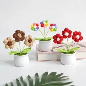Three handmade crochet puff flower potted plants in white ceramic pots for home decor