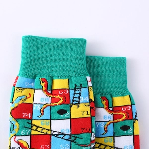 Detail of high-density knitted crew sock featuring colorful Snakes and Ladders patterns