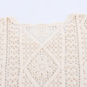 Neckline detail of beige hollow crochet knit top with intricate floral pattern
