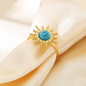Bohemian gold stainless steel sunburst ring with turquoise stone on silk fabric