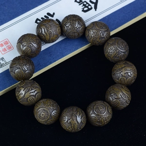 Close-up of golden silk nanmu wood beads featuring exquisite auspicious engravings