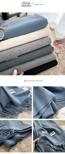 Detail of soft cashmere feel scarves with elegant tassel edges and multiple color options